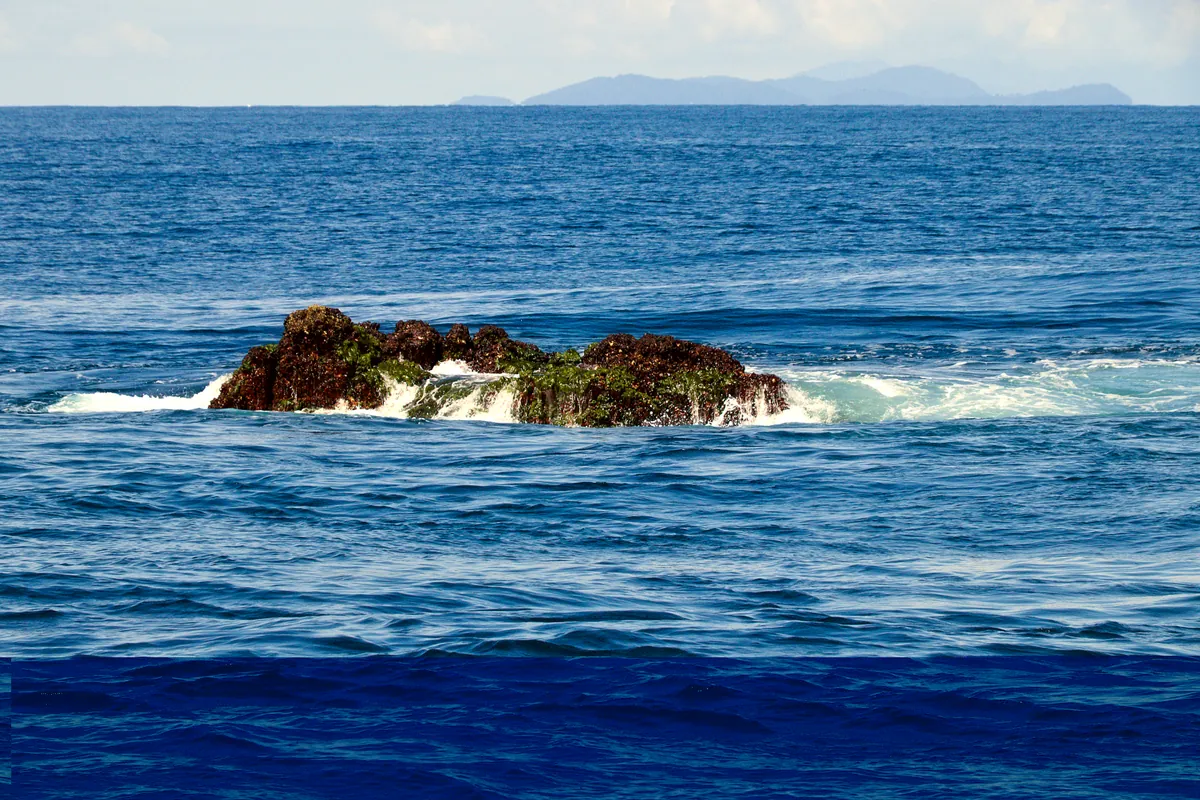 Richelieu Rock rising from the Andaman Sea on a sunny day